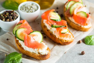 Somon, salatalık ve krem peynir bruschetta. İtalyan tapas antipasti sebzeler, otlar ve ızgara ciabatta ve baget ekmek üzerine. Sandviç.