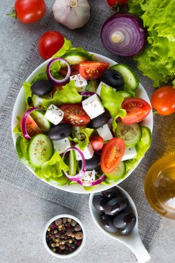 Kiraz domates, ruccola, roka, beyaz peynir, zeytin, salatalık, soğan ve baharat taze Yunan salatası yaptı. Sezar salatası ahşap arka plan üzerinde beyaz bir kase. Sağlıklı organik beslenme gıda kavramı.