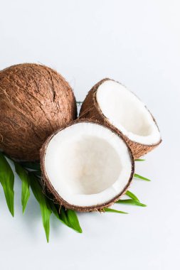 Beyaz arka planda yeşil yapraklı, yarım kesilmiş hindistan cevizi. Ayrı bir kavram. 