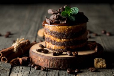 Çikolatalı kek siyah slatter kurulu ile nane, kahve çekirdekleri koyu arka plan, closeup fotoğraf üzerinde. Taze, lezzetli tatlı gıda kavramı. 