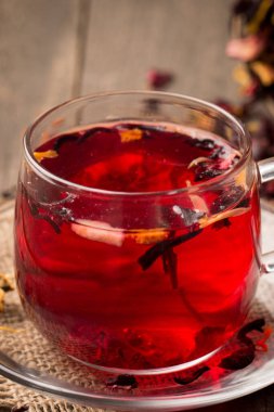 Tahta arka planda bir fincan taze kırmızı çay.