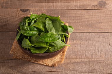 Tahta arka planda yeşil ıspanak yaprakları. Organik gıda konsepti. 