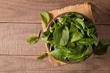 Tahta arka planda yeşil ıspanak yaprakları. Organik gıda konsepti. 