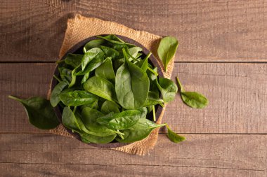 Tahta arka planda yeşil ıspanak yaprakları. Organik gıda konsepti. 