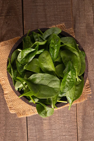 Tahta arka planda yeşil ıspanak yaprakları. Organik gıda konsepti. 