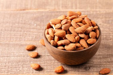 Kahverengi ahşap kasede çiğ badem. Organik gıda konsepti. 