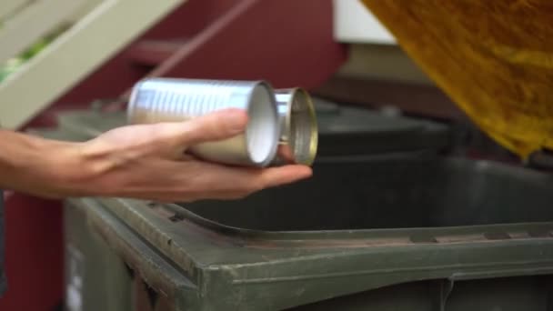 Persona pone latas de estaño en la papelera de reciclaje con tapa amarilla, primer plano — Vídeos de Stock