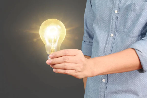 hand holding a light bulb with energy