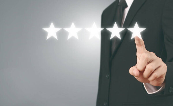 Hand touching five star symbol to increase rating 