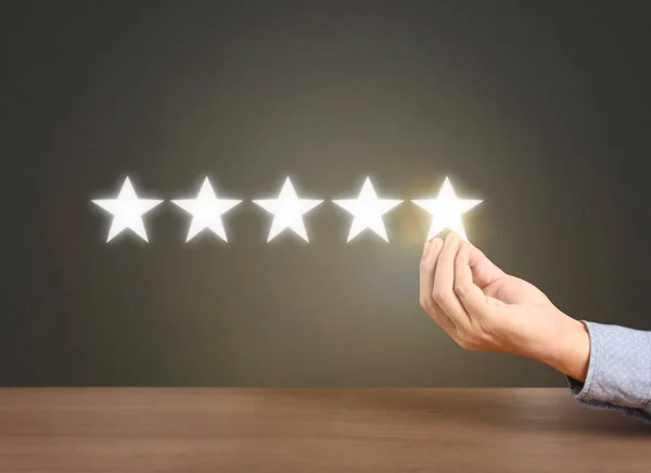 Hand touching five star symbol to increase rating