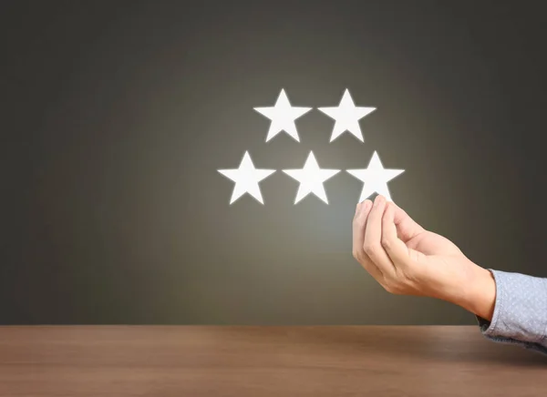 Hand touching five star symbol to increase rating