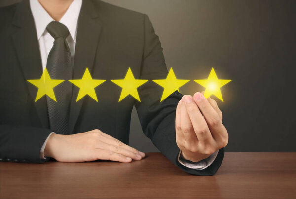 Hand touching five star symbol to increase rating 