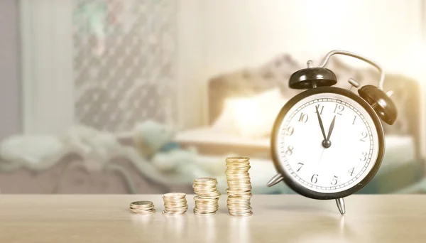 El tiempo es dinero, reloj de mesa con monedas — Foto de Stock