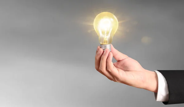 Hand of holding illuminated light bulb — Stock Photo, Image