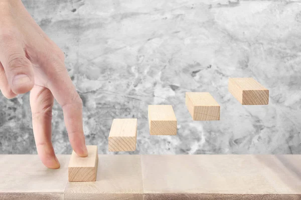 Рука подібна людина піднімає іграшку сходи дерев'яні — стокове фото