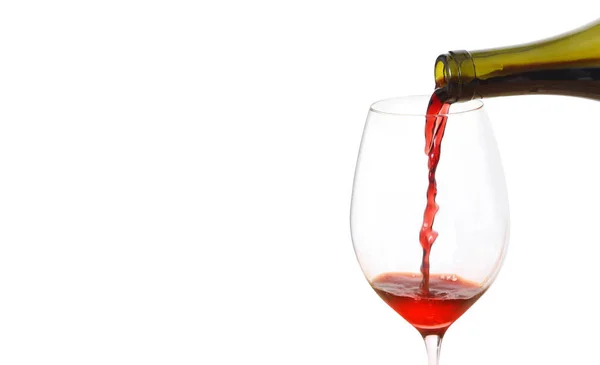 Pouring red wine into glass from bottle against white background — 图库照片