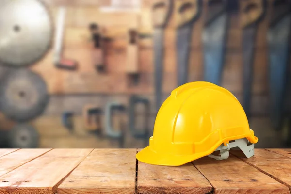 Foreman safety helmet and coin on a wooden table — Stock Photo, Image