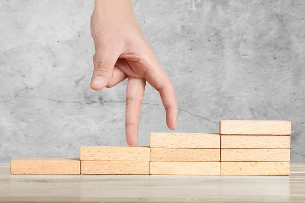 Comparación de la mano persona intensificando el apilamiento de bloques de madera como escalera de escalón —  Fotos de Stock