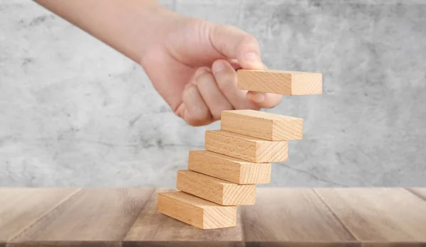 Comparación de la mano persona intensificando el apilamiento de bloques de madera como escalera de escalón —  Fotos de Stock