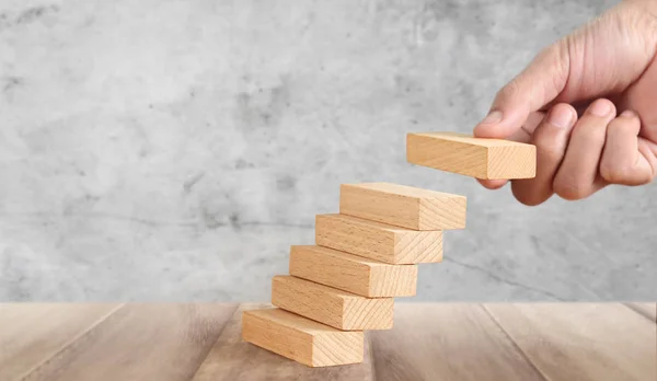 Handähnlicher Mensch, der Holzklötze stapelt wie eine Treppe — Stockfoto