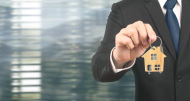 Emlakçı ev anahtarlarını elden teslim ediyor.