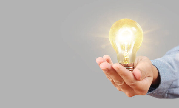 Hand of holding illuminated light bulb, innovation inspiration c