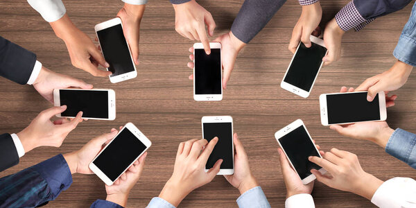 Hand holding smartphone with blank screen  positions angled and vertical isolated