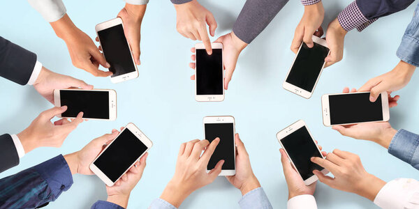 Hand holding smartphone with blank screen  positions angled and vertical isolated