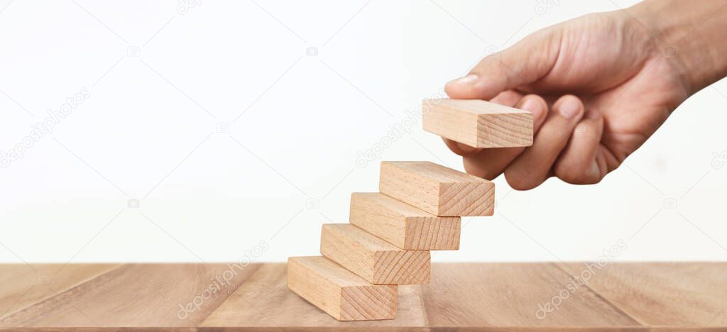 Hand arranging a wood block stacking as step stair, Business concept growth success process