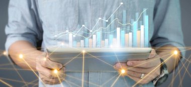 İş planı grafiği büyümesi ve grafiğin artışı, elinde tablet, işinde olumlu göstergeler