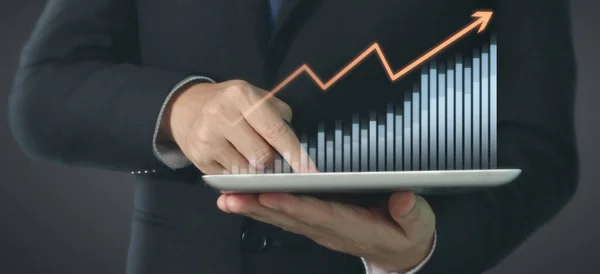 グラフの成長を計画し 彼のビジネスでチャートの積極的な指標の増加 手元のタブレット — ストック写真