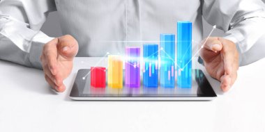 İşadamı, elinde tabletle iş yerinde grafik büyümesi ve grafik artışı planlıyor