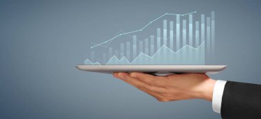 İşadamı, elinde tabletle iş yerinde grafik büyümesi ve grafik artışı planlıyor