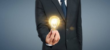 Aydınlatılmış ampulü tutan el. Fikir yeniliği ilham konsepti