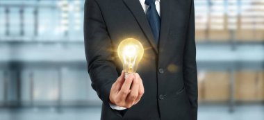 Aydınlatılmış ampulü tutan el. Fikir yeniliği ilham konsepti