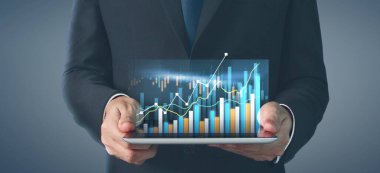 İş planı grafiği büyümesi ve grafiğin artışı, elinde tablet, işinde olumlu göstergeler