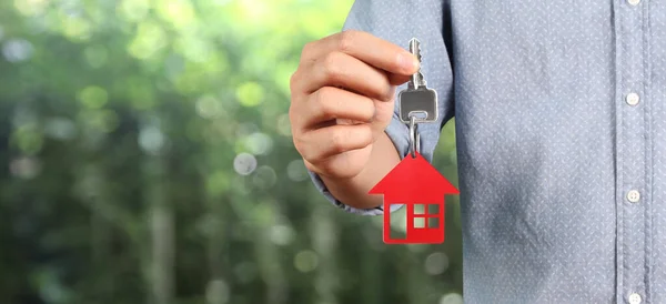 Real estate agent handing over house keys in hand