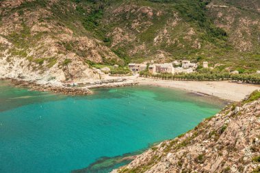 Turkuaz Akdeniz, plaj ve deniz de Giottani üzerinde Cap Corse tarafından kayalık bir manzara çevrili Corsica'deki / daki limanda