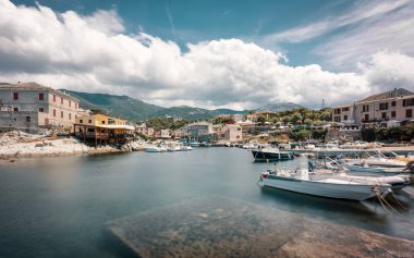 Balıkçı tekneleri düşük çekim görüntü Centuri Cap Corse barlar ve restoranlar uzakta Dağları ile çevrili Corsica'deki / daki üzerinde küçük limanında demirlemiş