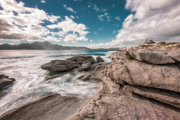 プンタ Caldanu 距離でカルヴィとコルシカ島の遮へい Balagne 領域の近くでジェノヴァの監視塔は 海岸の岩を洗う波の劇的な長時間露光画像 — ストック写真