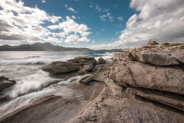 プンタ Caldanu 距離でカルヴィとコルシカ島の遮へい Balagne 領域の近くでジェノヴァの監視塔は 海岸の岩を洗う波の長時間露光画像 — ストック写真
