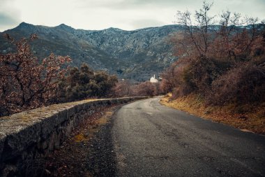 Düşük bir taş duvar Köyü ve Corsica Balagne bölgesinin dağlarında Ville di Paraso kilise tarafından sınırlanmıştır asfalt yol
