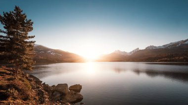 Güneş ayarı kar arkasında dağ gölü Calacuccia Merkezi Corsica'deki / daki şapkalı