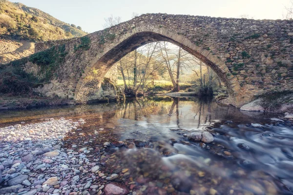 Antiguo puente de piedra sobre el río que fluye en Córcega — Foto de Stock