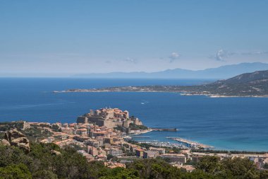 Antik Kale ve Korsika 'nın Balagne bölgesindeki Calvi limanı. Uzaklarda Kaptan Corse ile çevrili mavi Akdeniz ile çevrili.
