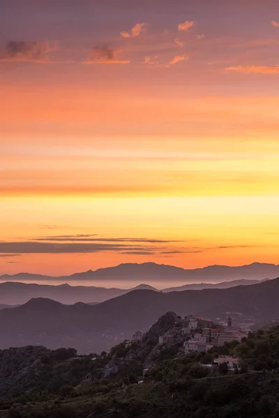 Dawn breaking over the silhouetted coastline of Cap Corse and the ancient mountain village of Speloncato in Corsica