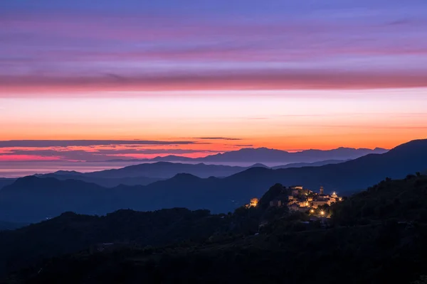 キャップコルセとコルシカ島のSpeloncatoの古代の山の村のシルエットの海岸線を突破夜明け — ストック写真