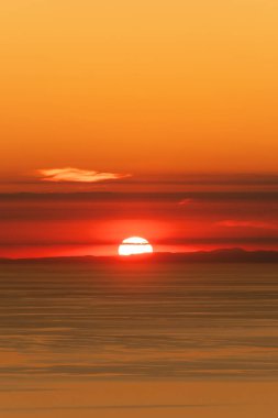 Fransa kıyı şeridinin gerisinde batan güneş, Korsika 'dan sakin Akdeniz boyunca görüldü.