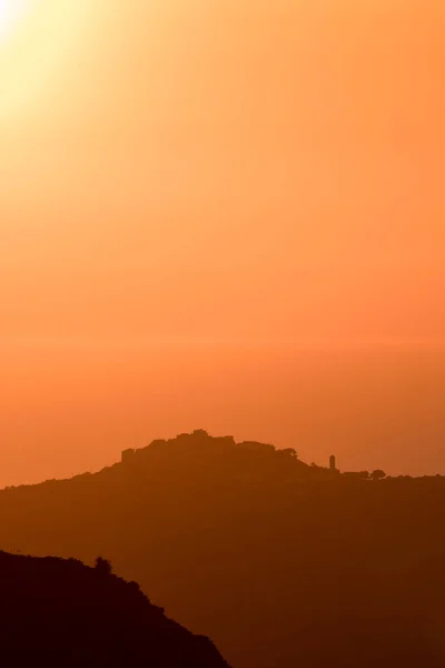 前景にコルシカ島のSant Antoninoのシルエットの丘の上の村と地中海の夕日 — ストック写真