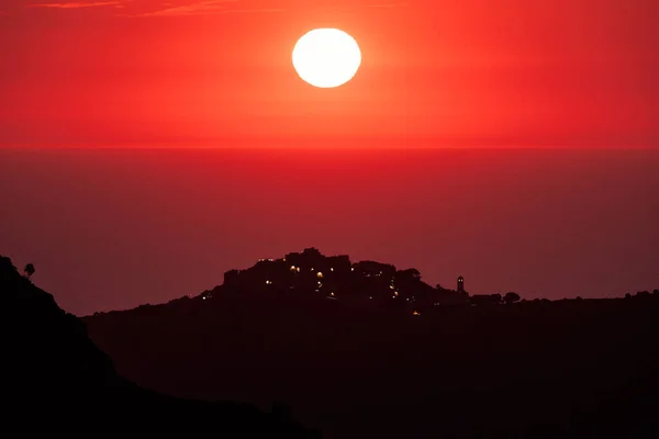 前景にコルシカ島のSant Antoninoのシルエットの丘の上の村と地中海の赤い夕日 — ストック写真